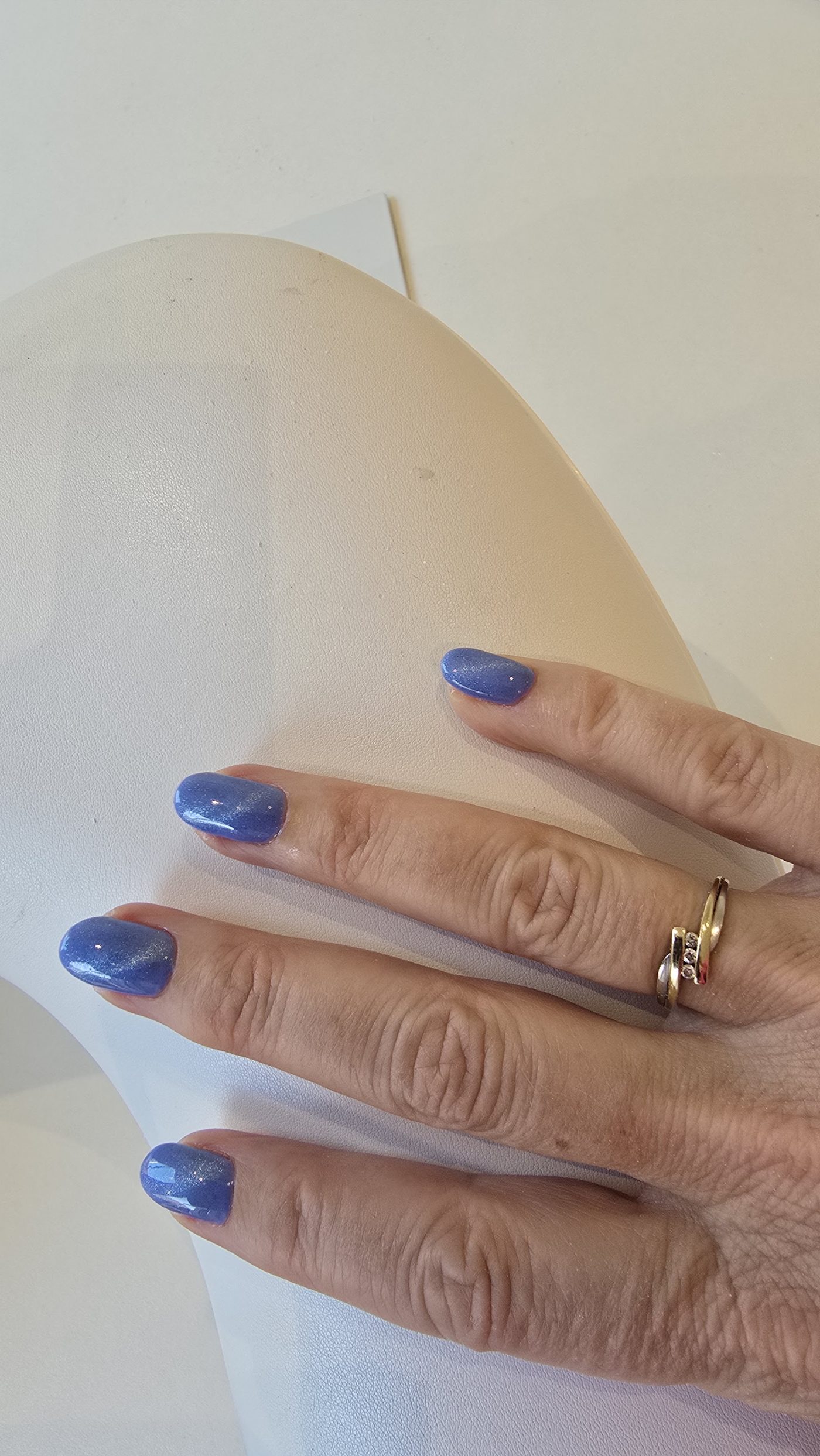 Blauwe gelnagels met een gouden ring