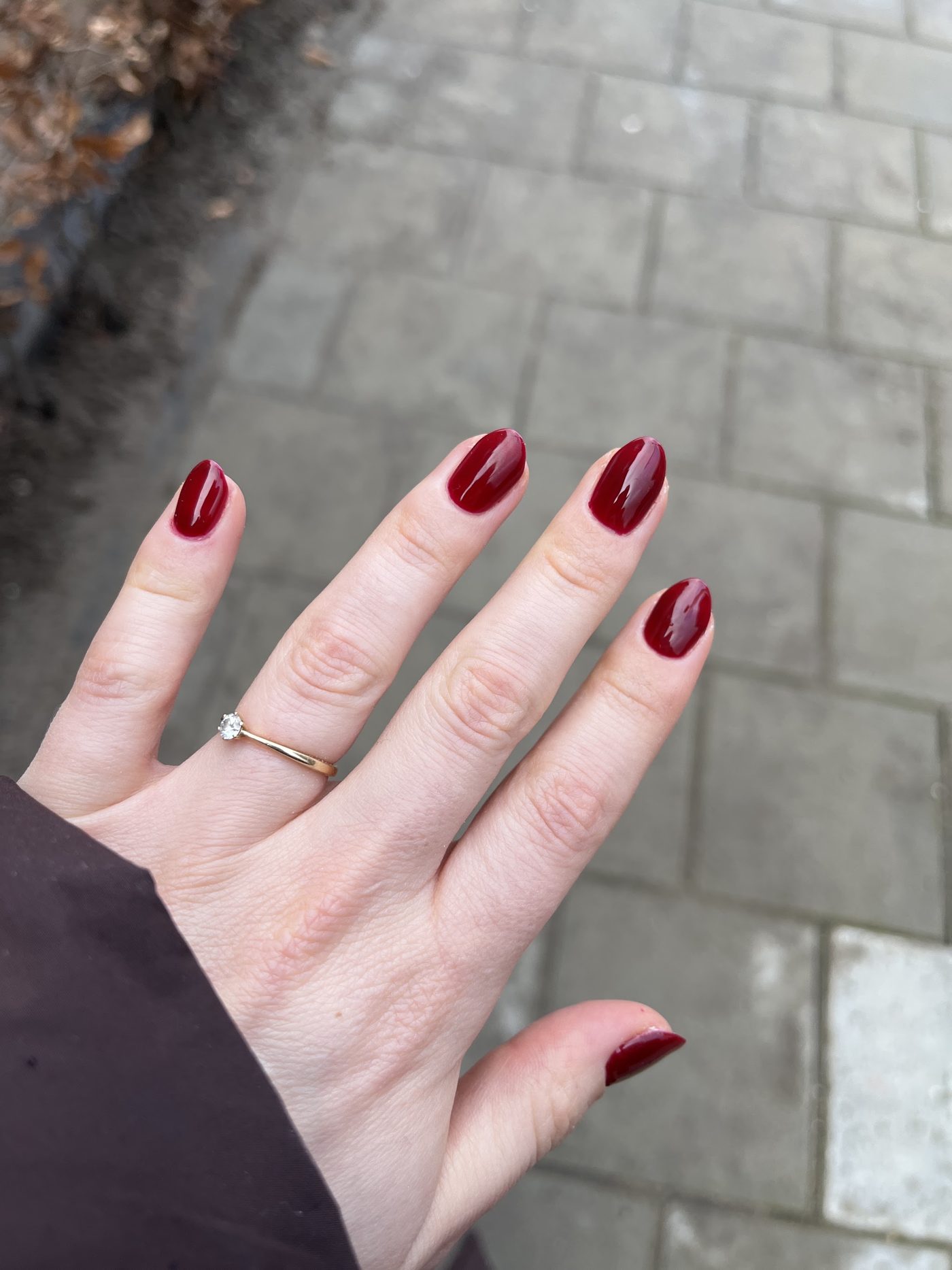 Donkerrode glanzende nagels met een dunne ring
