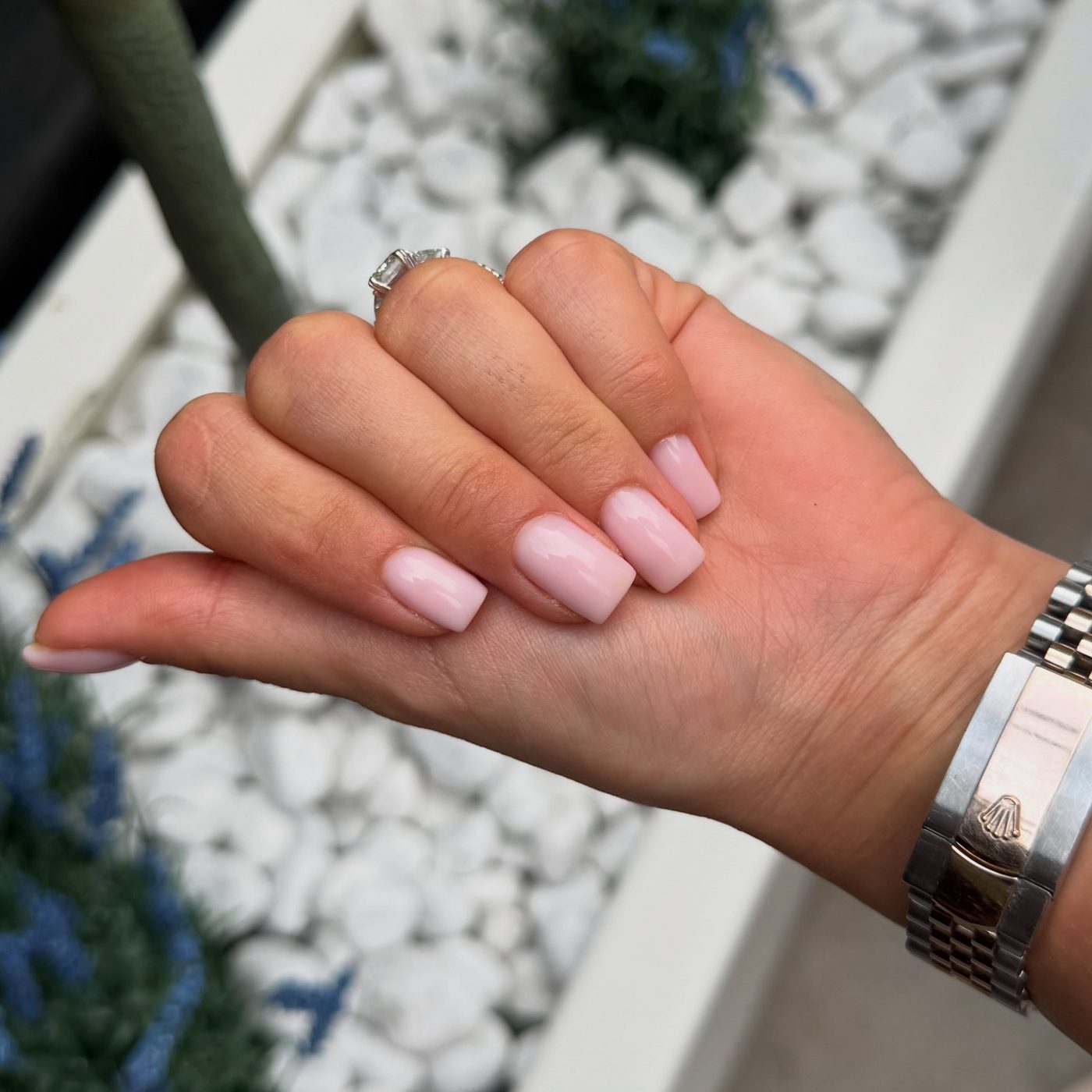 Zachtroze nagels boven witte steentjes