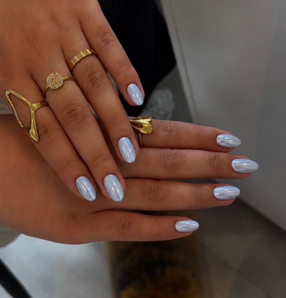 IJsblauwe glanzende nagels met gouden ringen